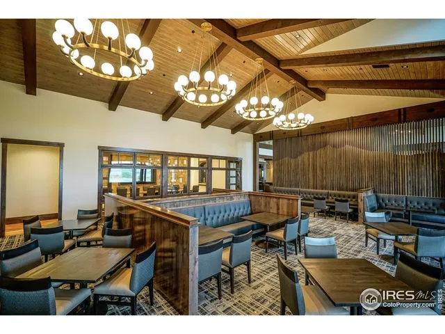 a living room with stainless steel appliances furniture a chandelier and a flat screen tv
