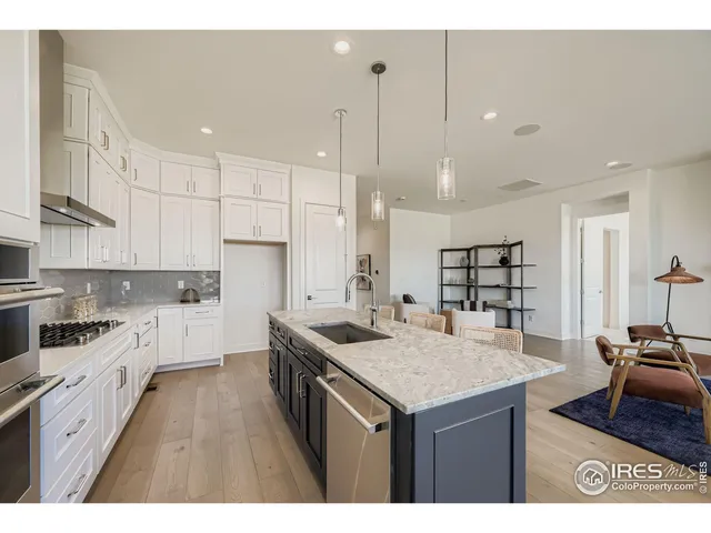 a kitchen with a sink a stove a refrigerator and white cabinets