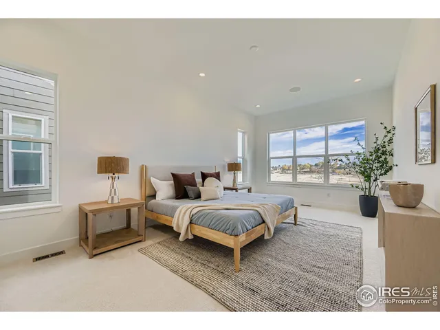 a spacious bedroom with a bed a couch and potted plant
