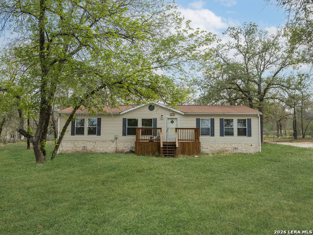 135 Savannah Ridge Von Ormy, TX 78073 - Photo 2 of 45 a front view of house with yard and trees in the background