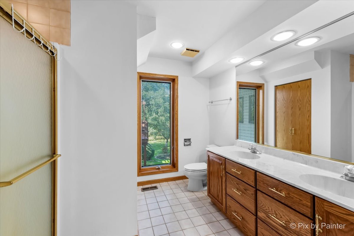 322 West Dowell Road McHenry, IL 60051 - Photo 13 of 40 a bathroom with a double vanity sink and a large mirror