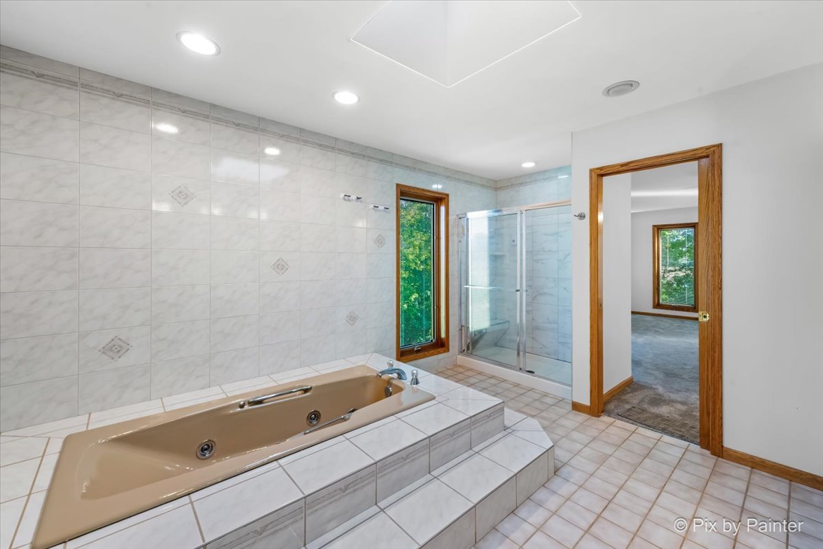 322 West Dowell Road McHenry, IL 60051 - Photo 23 of 40 a bathroom with a tub a mirror and a shower