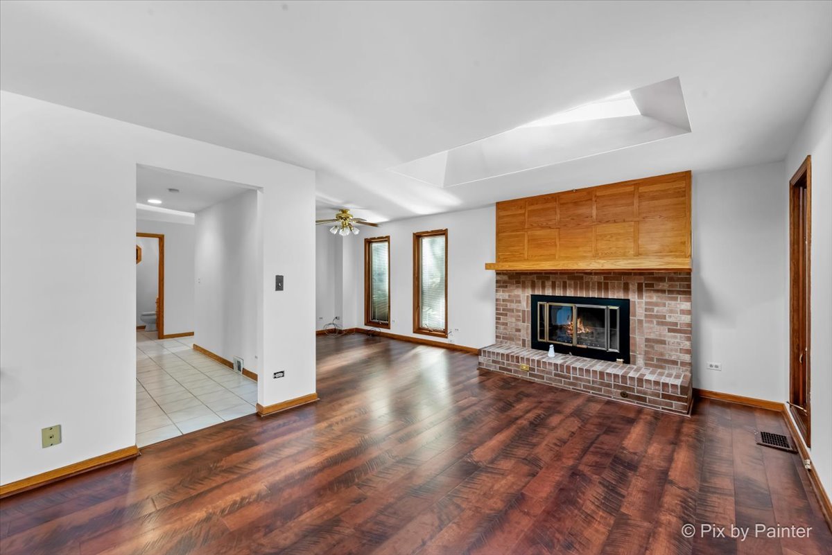 322 West Dowell Road McHenry, IL 60051 - Photo 6 of 40 an empty room with wooden floor fireplace and windows