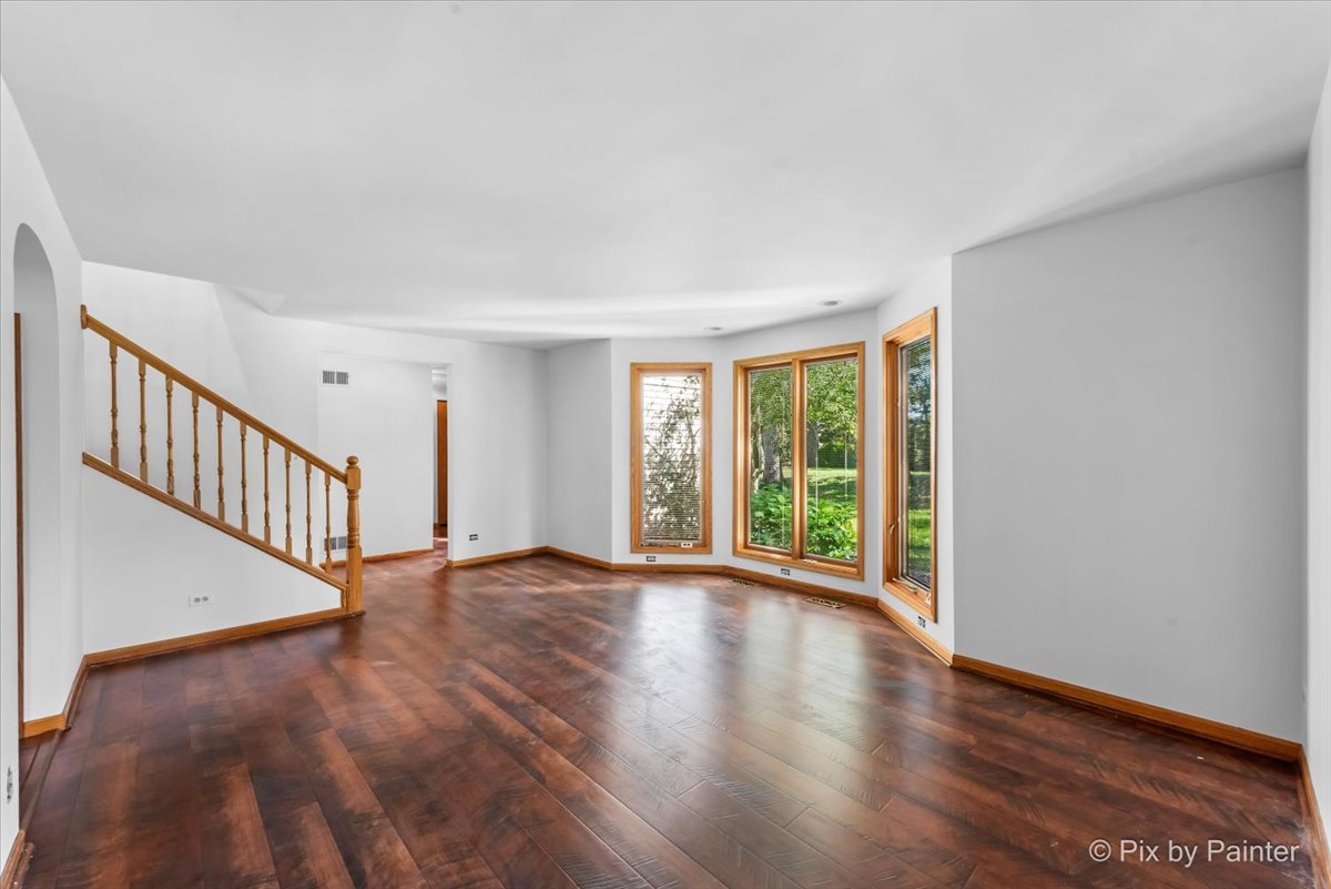 322 West Dowell Road McHenry, IL 60051 - Photo 8 of 40 a view of an empty room with wooden floor and fan