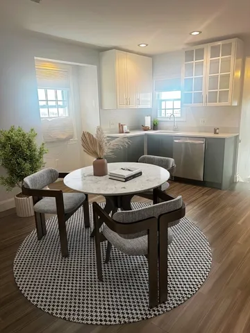 a view of a a dining room with furniture window and wooden floor