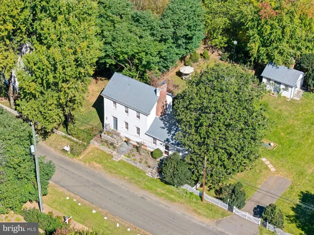 an aerial view of residential house with outdoor space and trees all around