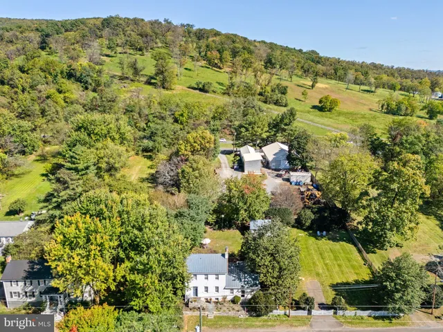 a view of a house with a yard and large trees