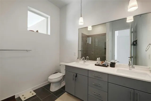 a bathroom with a toilet a sink a mirror and a shower