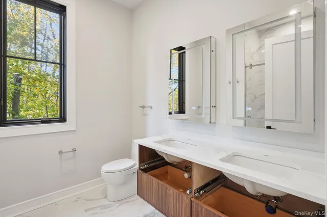 a bathroom with a sink a toilet and a window