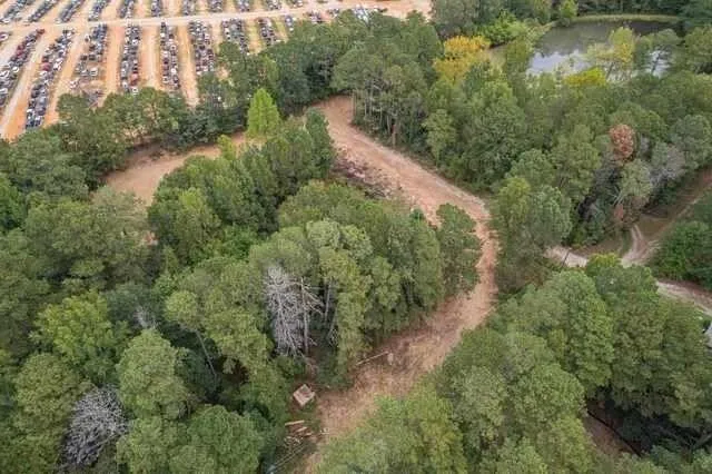 an aerial view of residential house with outdoor space and trees all around