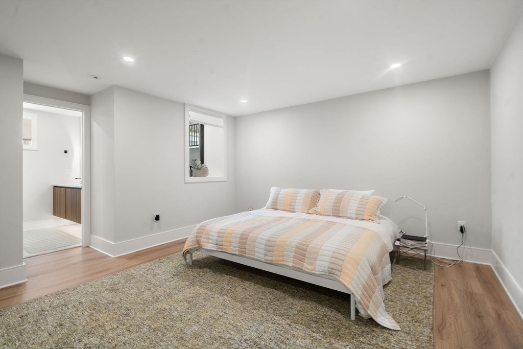 116 Thorndike Street, Unit 1 Brookline, MA 02446 - Photo 15 of 16 a bedroom with a bed and painting on the wall