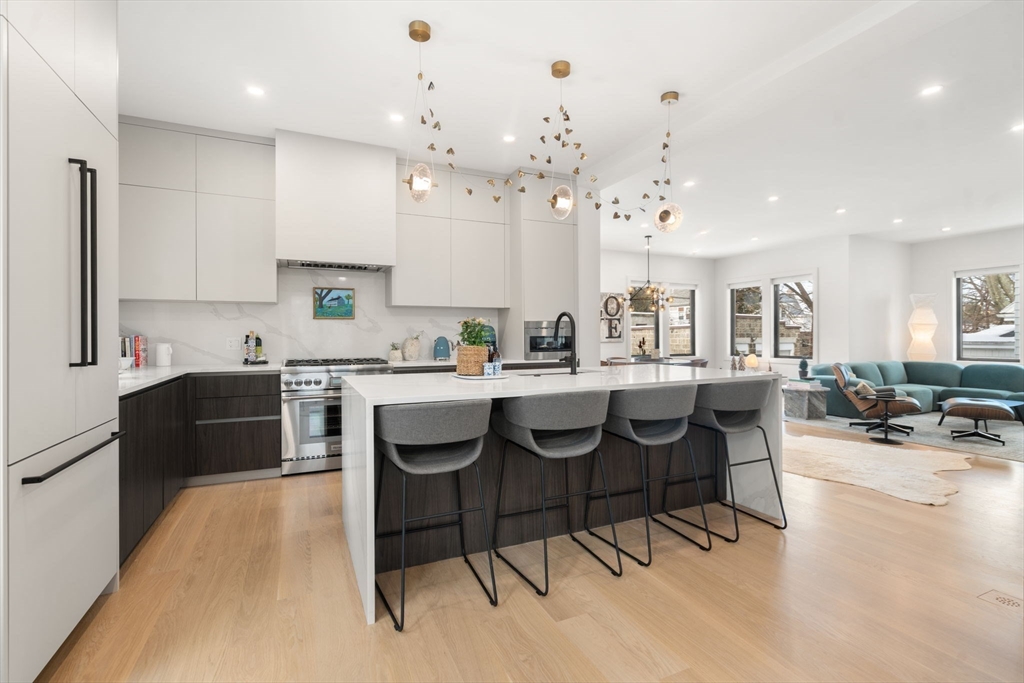 116 Thorndike Street, Unit 1 Brookline, MA 02446 - Photo 2 of 16 a large kitchen with kitchen island a dining table and chairs