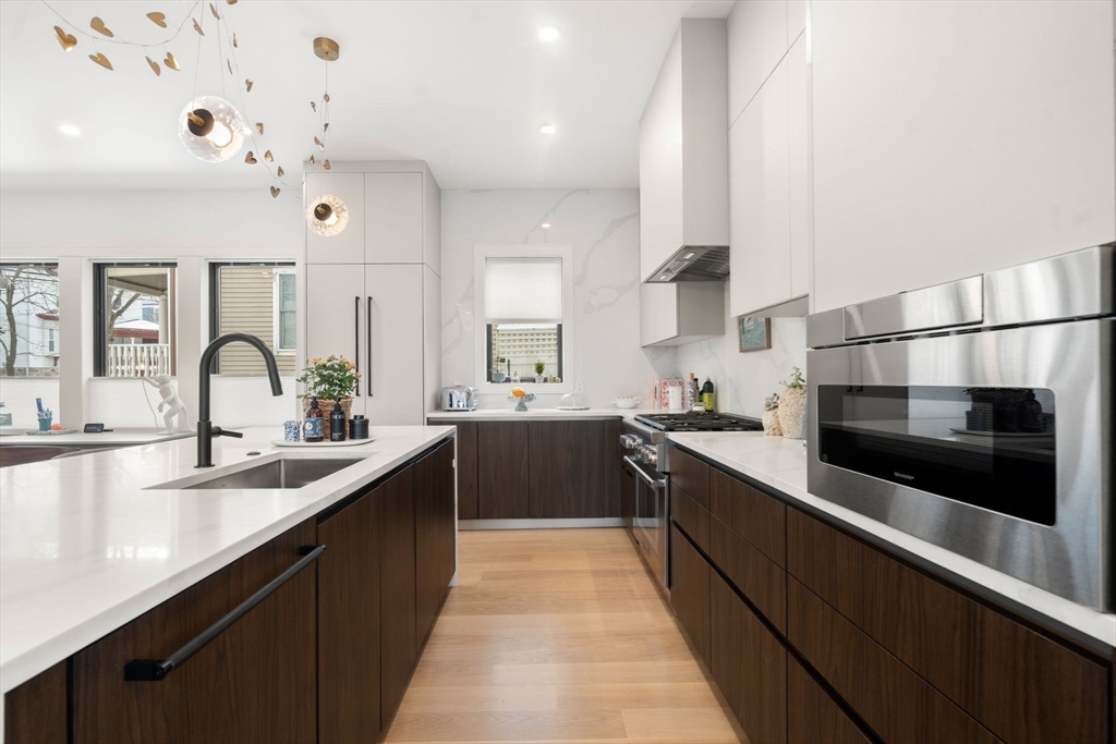 116 Thorndike Street, Unit 1 Brookline, MA 02446 - Photo 4 of 16 a large kitchen with stainless steel appliances