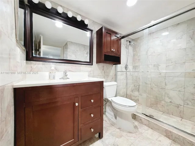 a bathroom with a sink vanity mirror and toilet