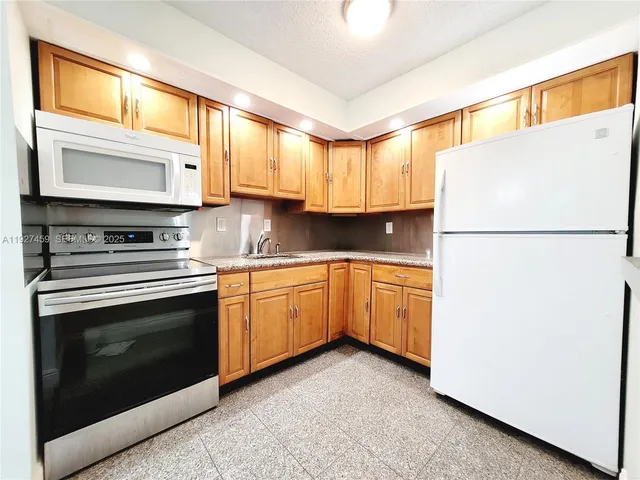 a kitchen with a refrigerator sink and cabinets