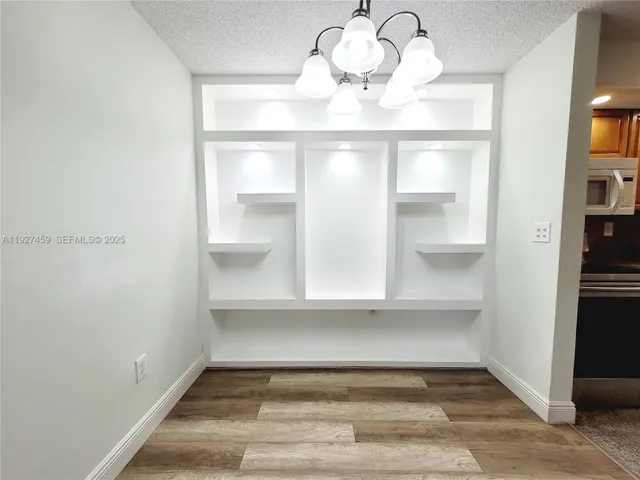 a view of a room with wooden floor and chandelier