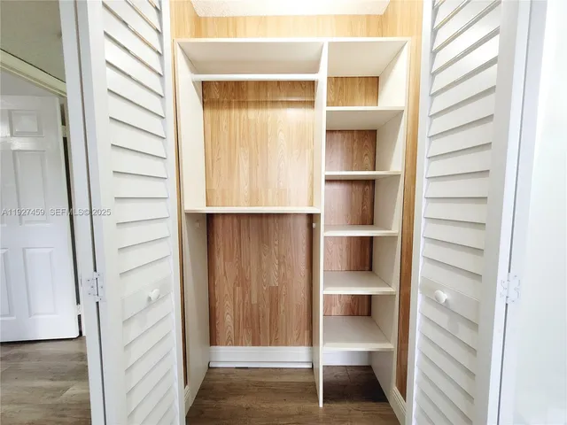 a view of walk in closet with empty racks