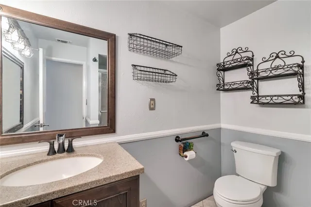 a bathroom with a granite countertop sink mirror and toilet