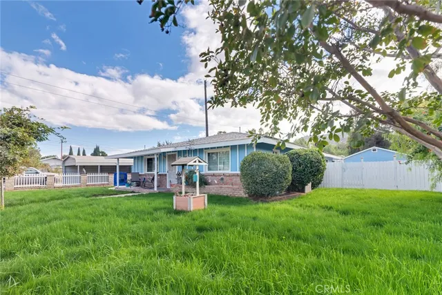 a view of a house with a yard and sitting area