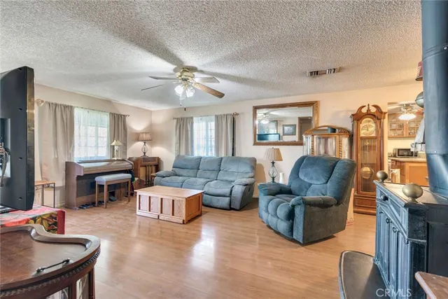 a living room with furniture kitchen view and a window