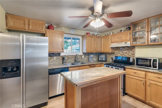 a kitchen with a refrigerator a sink and cabinets