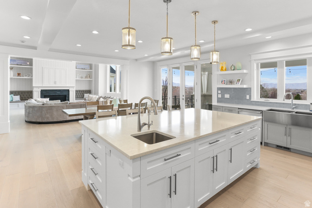 1354 South 800 East Mapleton, UT 84664 - Photo 20 of 129 Kitchen with light stone counters, a fireplace, a kitchen island with sink, and hanging light fixtures