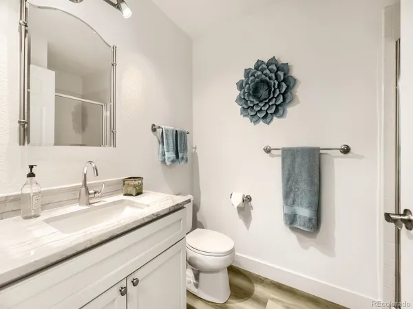 a bathroom with a granite countertop sink a toilet and a mirror