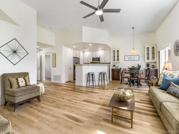 a living room with furniture and a flat screen tv with kitchen view