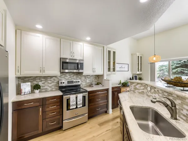 a kitchen with stainless steel appliances granite countertop a stove a sink and a refrigerator