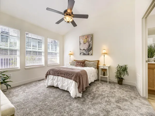 a spacious bedroom with a bed and a chandelier