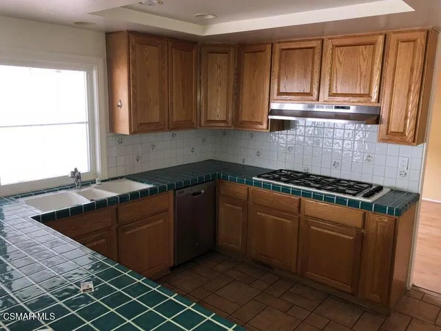 a kitchen with stainless steel appliances granite countertop a sink stove and cabinets