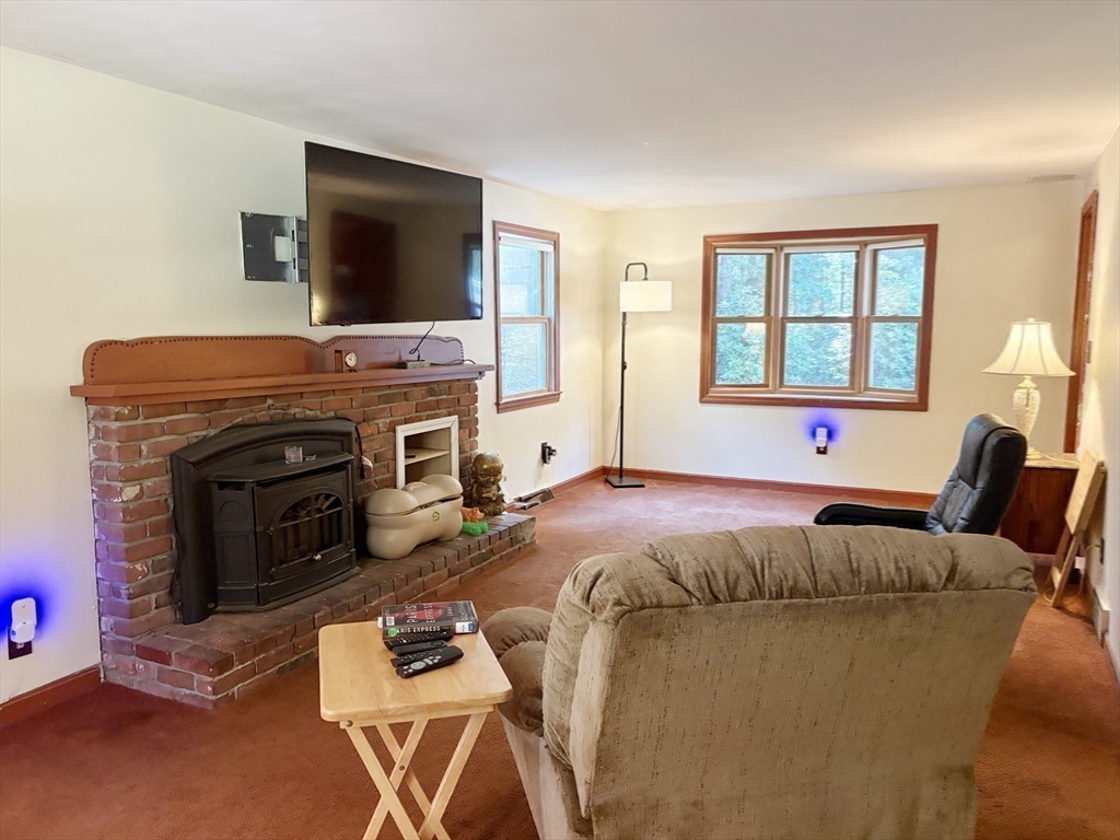 88 Colby Drive Halifax, MA 02338 - Photo 24 of 38 a bed sitting in a living room with furniture and a flat screen tv