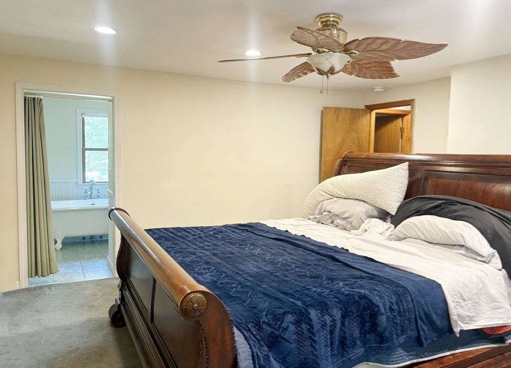 88 Colby Drive Halifax, MA 02338 - Photo 26 of 38 a bedroom with a bed and a chandelier