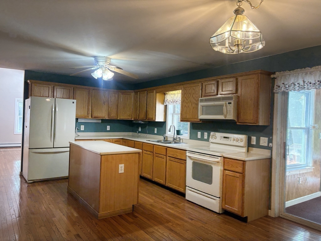88 Colby Drive Halifax, MA 02338 - Photo 3 of 38 a kitchen with stainless steel appliances granite countertop a refrigerator a sink dishwasher a stove and white countertops with wooden floor