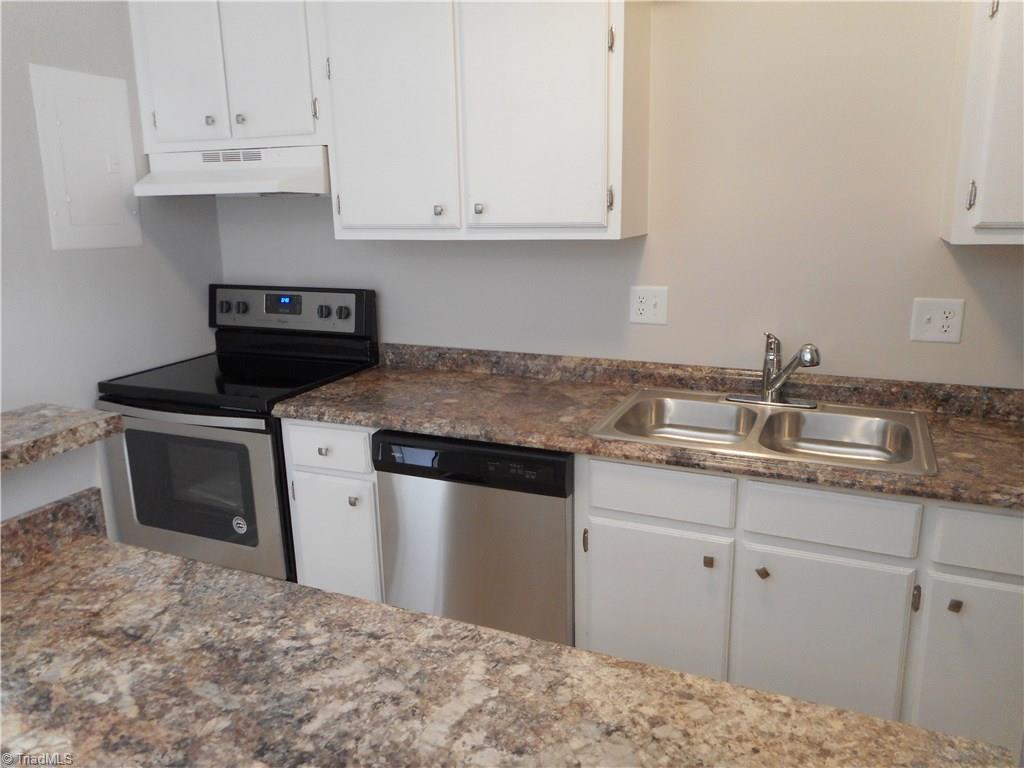 5725 Bramblegate Road, Unit F Greensboro, NC 27409 - Photo 12 of 30 Kitchen: Room features include fresh new paint, new vinyl flooring for easy cleaning, crown molding, bright cabinets with new counter tops, sink and fixtures. You also have a brand new SST dishwasher, slide in stove and refrigerator that stays with the home at closing. Behind us is the dining room, laundry room and sliding door to the patio. To the left side is the living room and half bath.