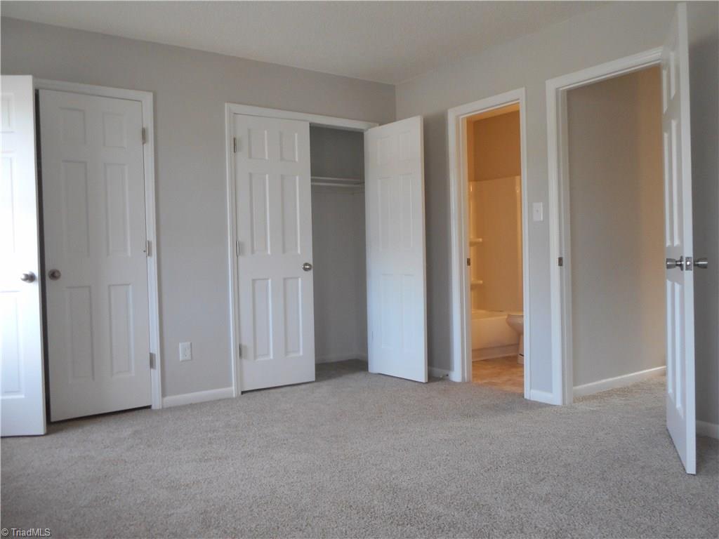 5725 Bramblegate Road, Unit F Greensboro, NC 27409 - Photo 15 of 30 Master Bedroom: Room features include fresh new paint, new carpet flooring, two windows for natural lighting and here we can see that you have two double door closets for all your fine clothes and shoes. The open door in the middle is to your own full size bathroom and the door on the right is the hallway.
