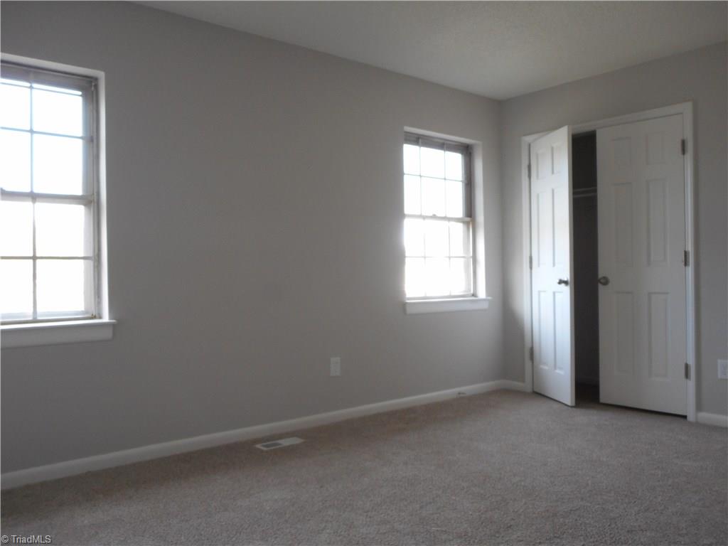 5725 Bramblegate Road, Unit F Greensboro, NC 27409 - Photo 16 of 30 Master Bedroom: Room features include fresh new paint, new carpet flooring, two windows for natural lighting and here we can see one of the two double door closets for all your fine clothes and shoes. Your master bedroom also has it's own full size bathroom located over on the right side.