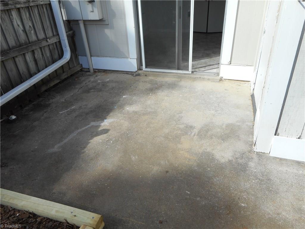 5725 Bramblegate Road, Unit F Greensboro, NC 27409 - Photo 3 of 30 Rear Patio Area: He can see the paved patio area where you can be sitting outside in you super cozy easy chair and enjoying a cool beverage on a warm summer day. The sliding door is to the kitchen and dining room.