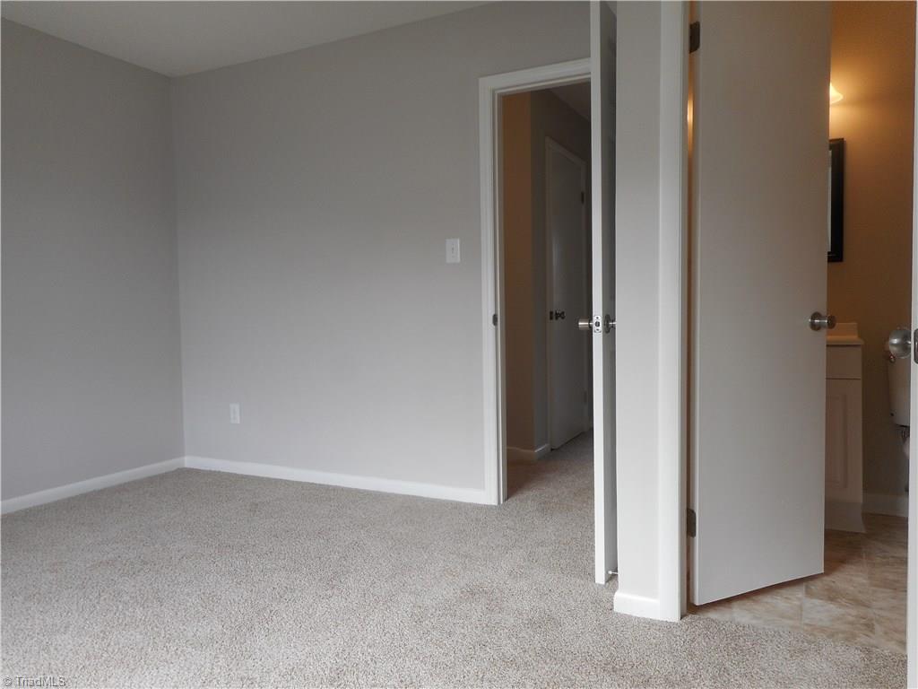 5725 Bramblegate Road, Unit F Greensboro, NC 27409 - Photo 22 of 30 Bedroom Two: Room features include fresh new paint, two windows for natural lighting, new carpet flooring and your own private full size bathroom through the open door on the right side. The open door in the middle is to the hallway.