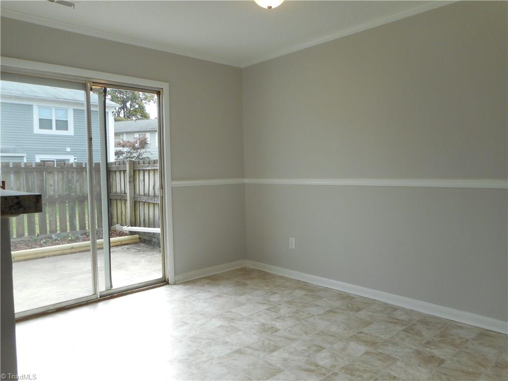 5725 Bramblegate Road, Unit F Greensboro, NC 27409 - Photo 8 of 30 Dining Room: Room features include new vinyl flooring for easy cleaning, fresh new paint, a decorative chair rail to help protect the walls and crown molding. The sliding door opens to the patio and garden area. The kitchen is to the left side and the laundry room is to the right side.