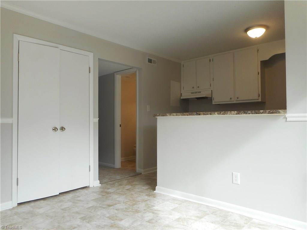 5725 Bramblegate Road, Unit F Greensboro, NC 27409 - Photo 10 of 30 Dining Room: Room features include new vinyl flooring for easy cleaning, fresh new paint, a decorative chair rail to help protect the walls and crown molding. The double door opens to the laundry room. The kitchen is to the right side and the half bath is the open door in the middle. The living is down the hall to the left.