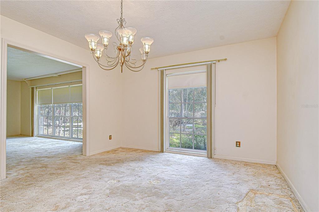 2608 Bellwood Drive Brandon, FL 33511 - Photo 12 of 27 an empty room with chandelier fan and wooden floor