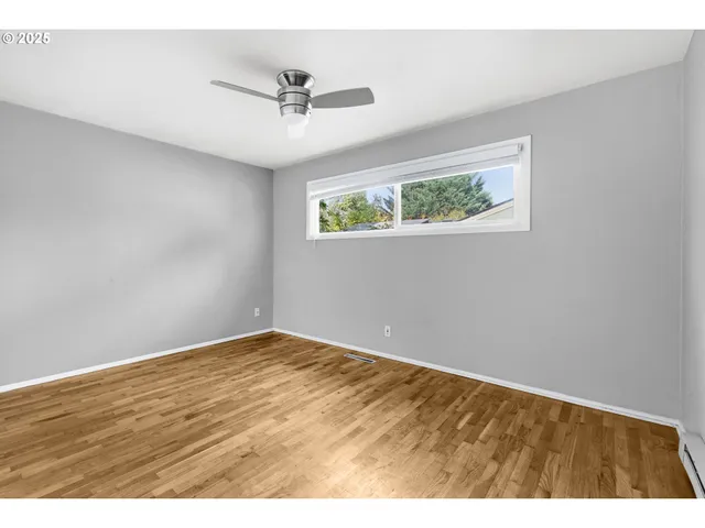a view of an empty room with closet and a window