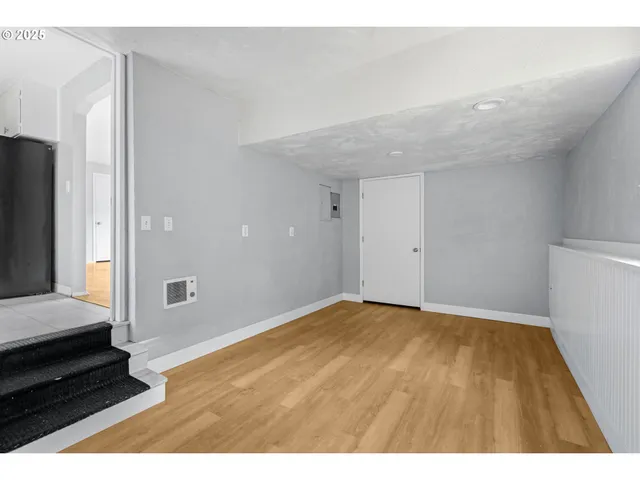 view of an empty room with wooden floor and a window