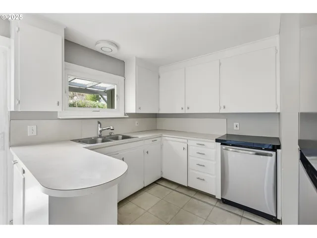 a kitchen with stainless steel appliances granite countertop a sink stove and white cabinets with wooden floor