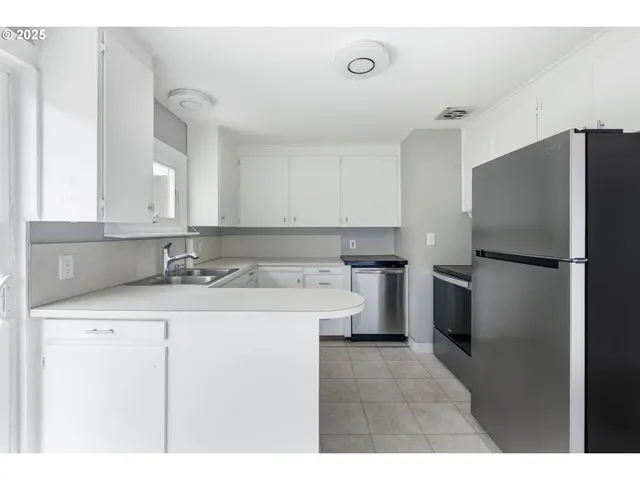 a kitchen with a sink a refrigerator and a stove