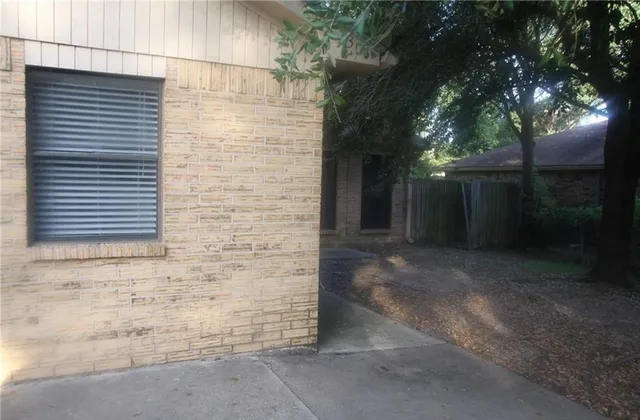a view of a brick house with a large tree