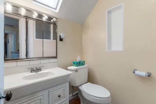 a bathroom with a sink a toilet a mirror and shower