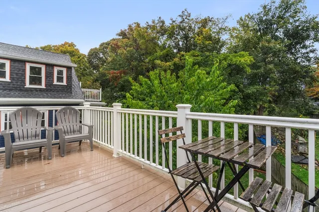 a view of a house with wooden deck and furniture