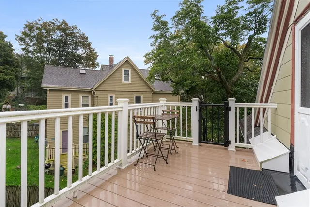 a view of a house with wooden deck and furniture